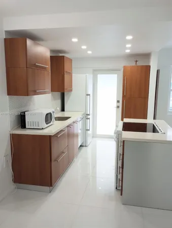 a large kitchen with stainless steel appliances a sink a stove and a refrigerator