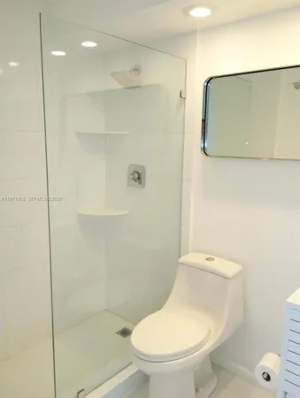 a white toilet sitting next to a bathroom sink