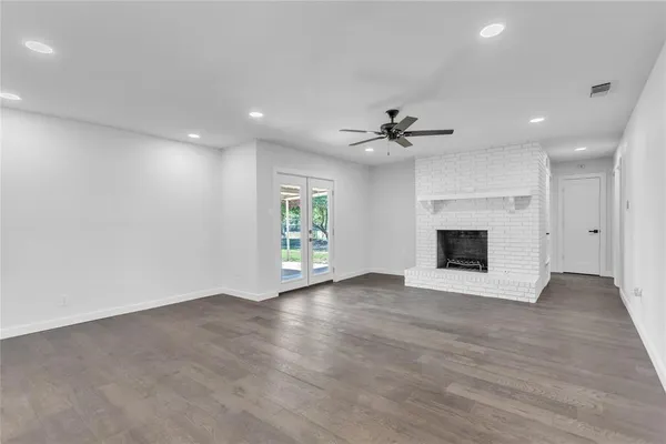 an empty room with windows and a fireplace
