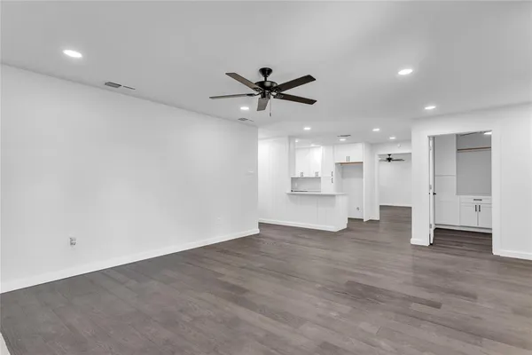 a view of a big room with wooden floor and a kitchen