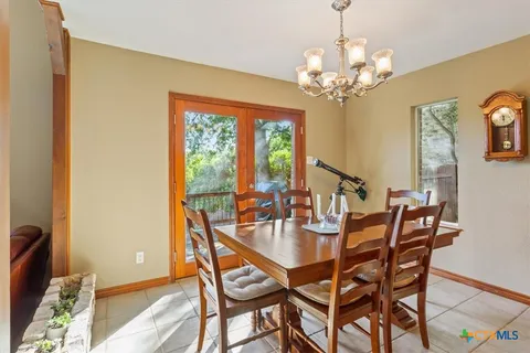a dining room with furniture a chandelier and wooden floor