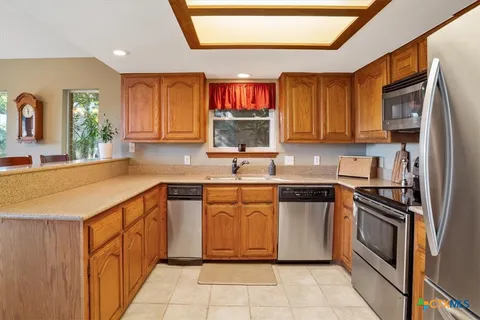 a kitchen with stainless steel appliances granite countertop a sink and dishwasher a stove top oven with wooden floor