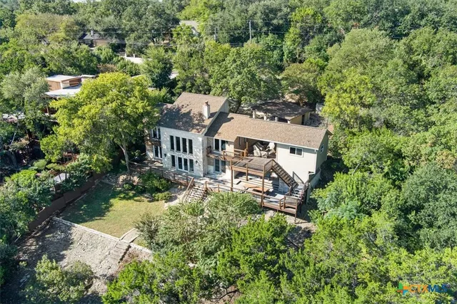 an aerial view of a house with yard and green space