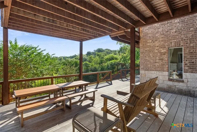 a view of chairs and table in patio with wooden floor