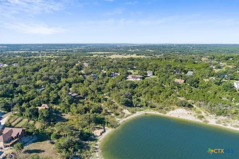 an aerial view of residential houses with outdoor space and trees