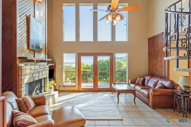a living room with fireplace furniture and a floor to ceiling window
