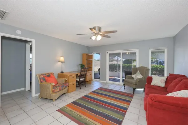 a living room with furniture two lamp and a large window