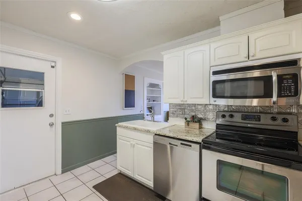 a kitchen with stainless steel appliances a stove microwave and sink