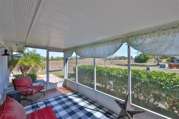 a living room with furniture and a floor to ceiling window