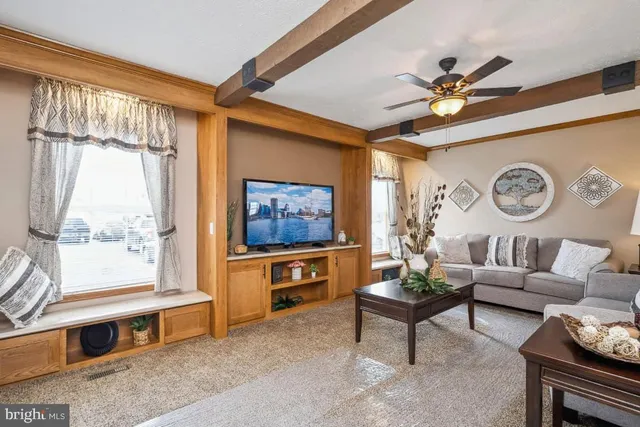 a living room with furniture a ceiling fan and a window