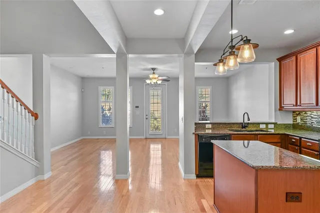 a kitchen with granite countertop a sink cabinets and wooden floor