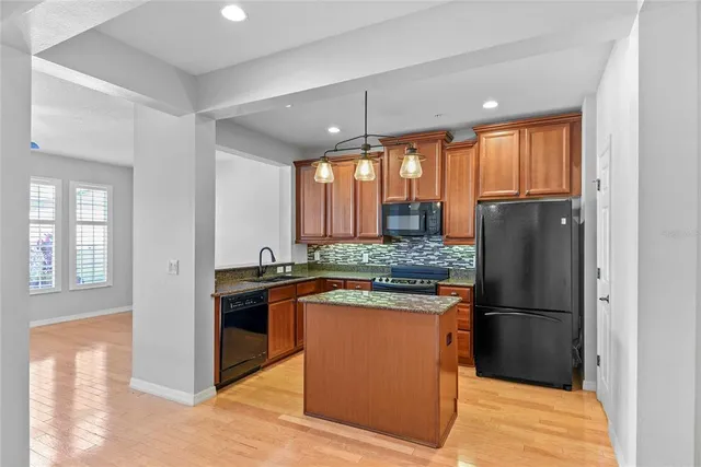 a kitchen with granite countertop a refrigerator and a sink