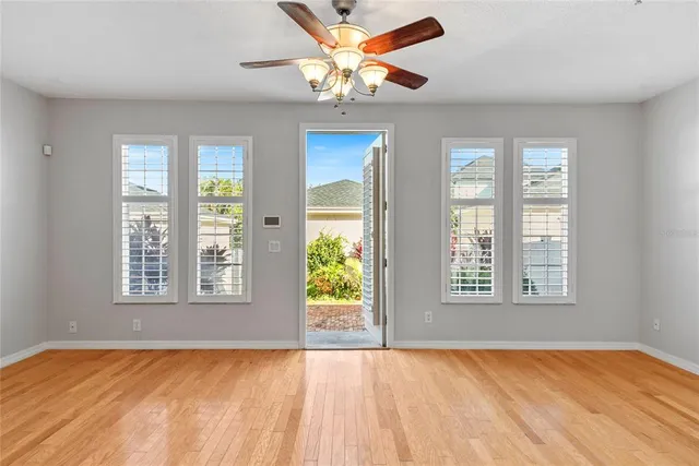 a view of an empty room with window and a kitchen