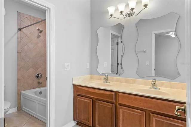 a bathroom with a double vanity sink mirror and bathtub