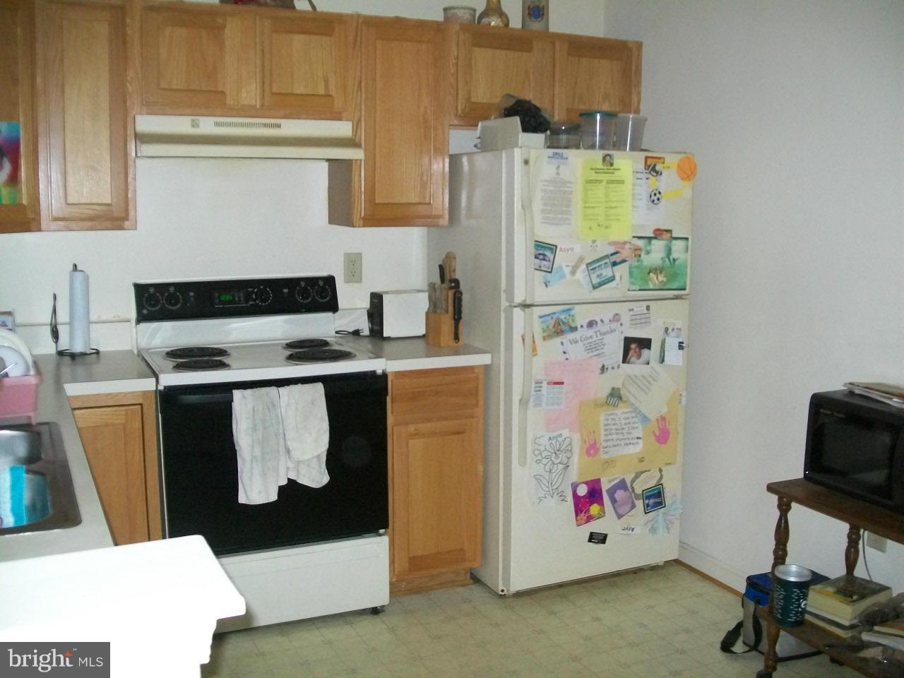 309 Assembly Point Court Odenton, MD 21113 - Photo 4 of 25 a utility room with fridge and workspace