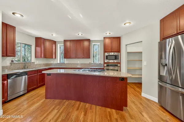 a view of a dining room with furniture a chandelier and wooden floor