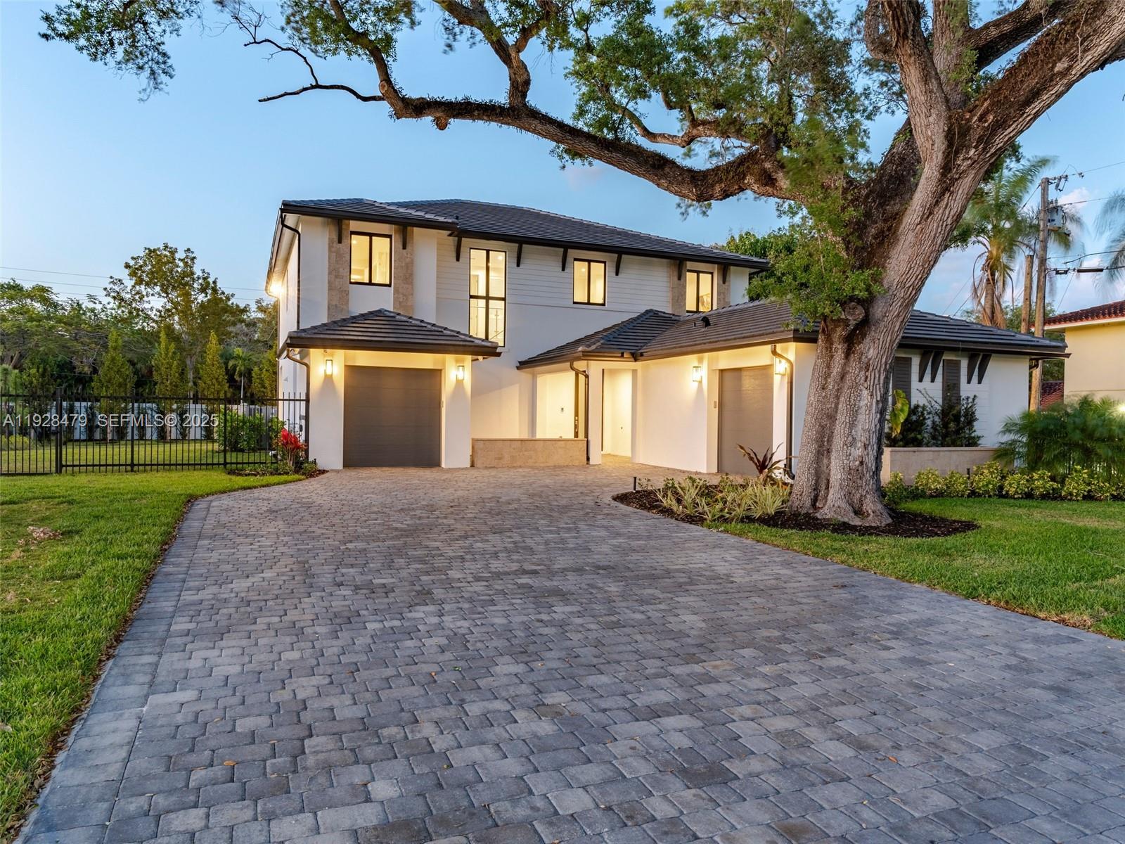 7285 Southwest 72nd Street Miami, FL 33143 - Photo 12 of 53 a front view of a house with a yard and garage