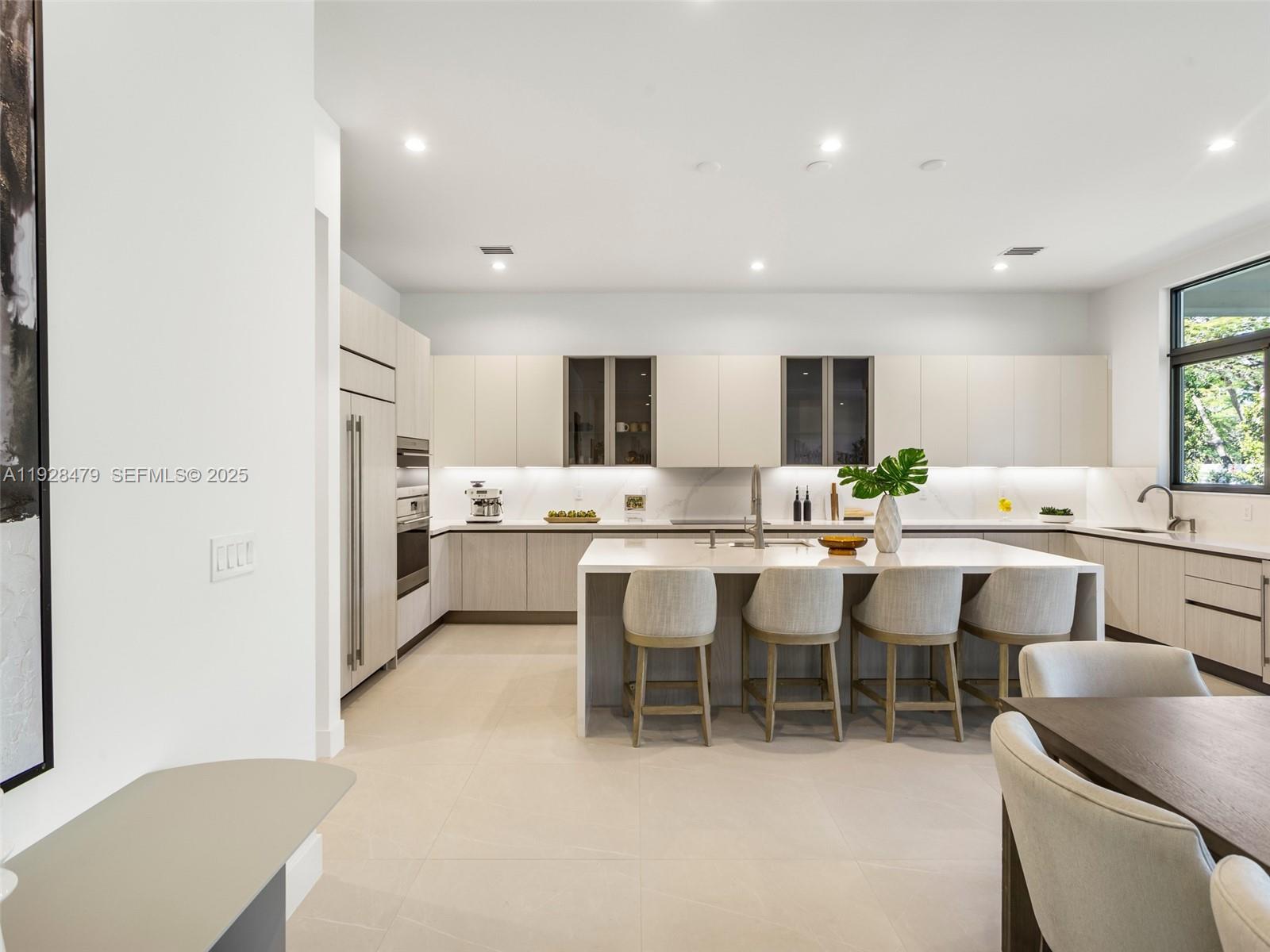 7285 Southwest 72nd Street Miami, FL 33143 - Photo 15 of 53 a large white dining hall with stainless steel appliances kitchen island granite countertop furniture and a living room