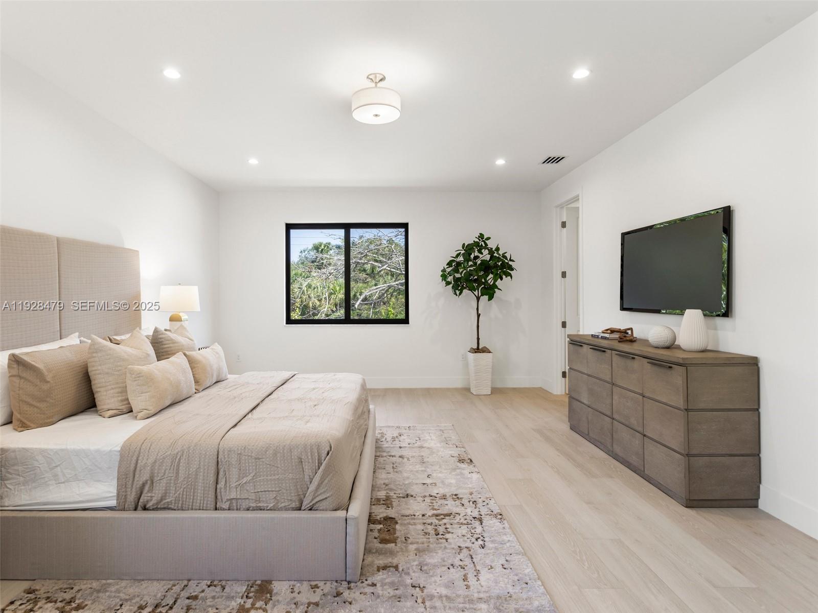 7285 Southwest 72nd Street Miami, FL 33143 - Photo 28 of 53 a bedroom with a large bed and a flat screen tv