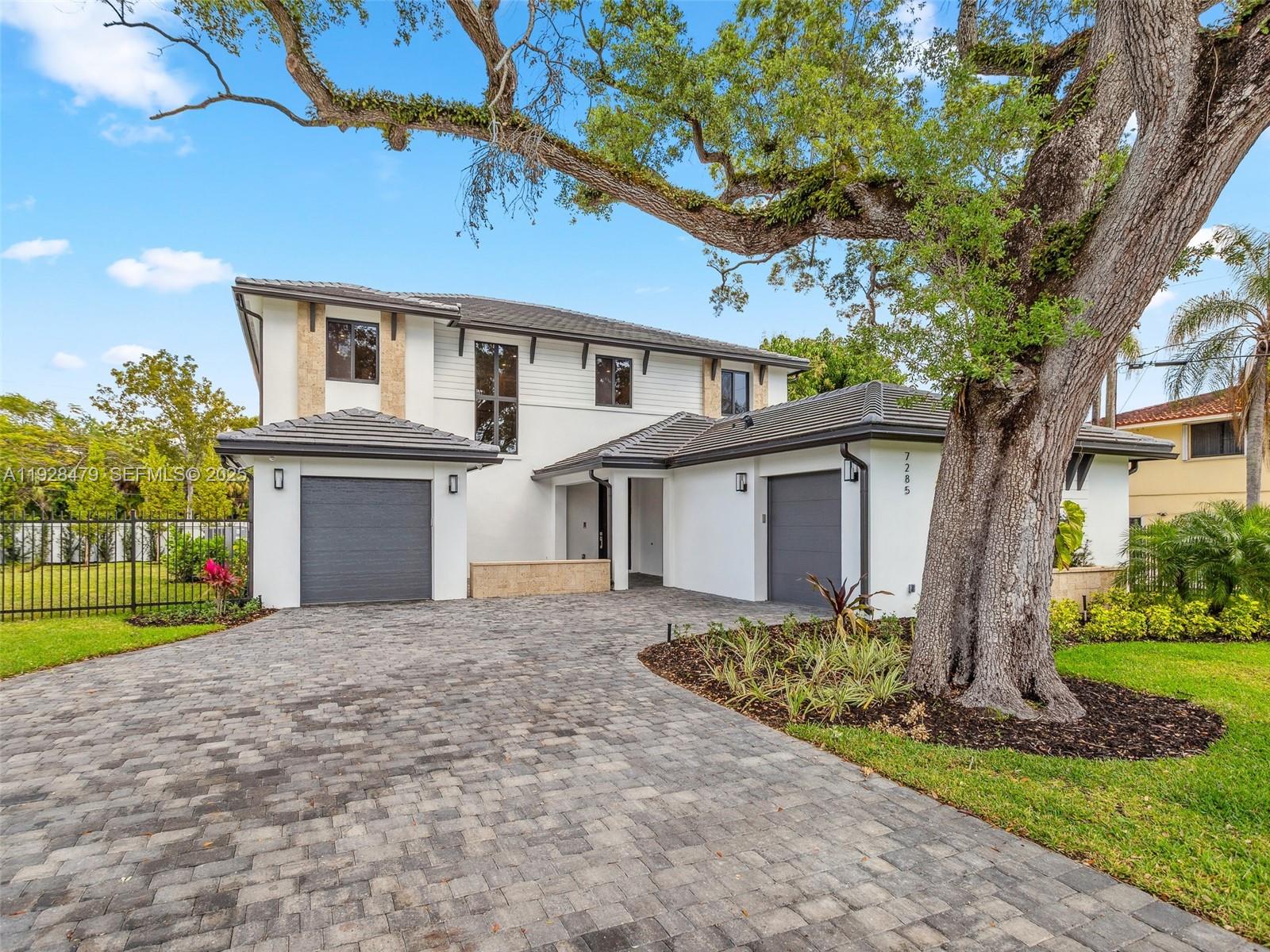 7285 Southwest 72nd Street Miami, FL 33143 - Photo 6 of 53 a front view of a house with a yard and garage