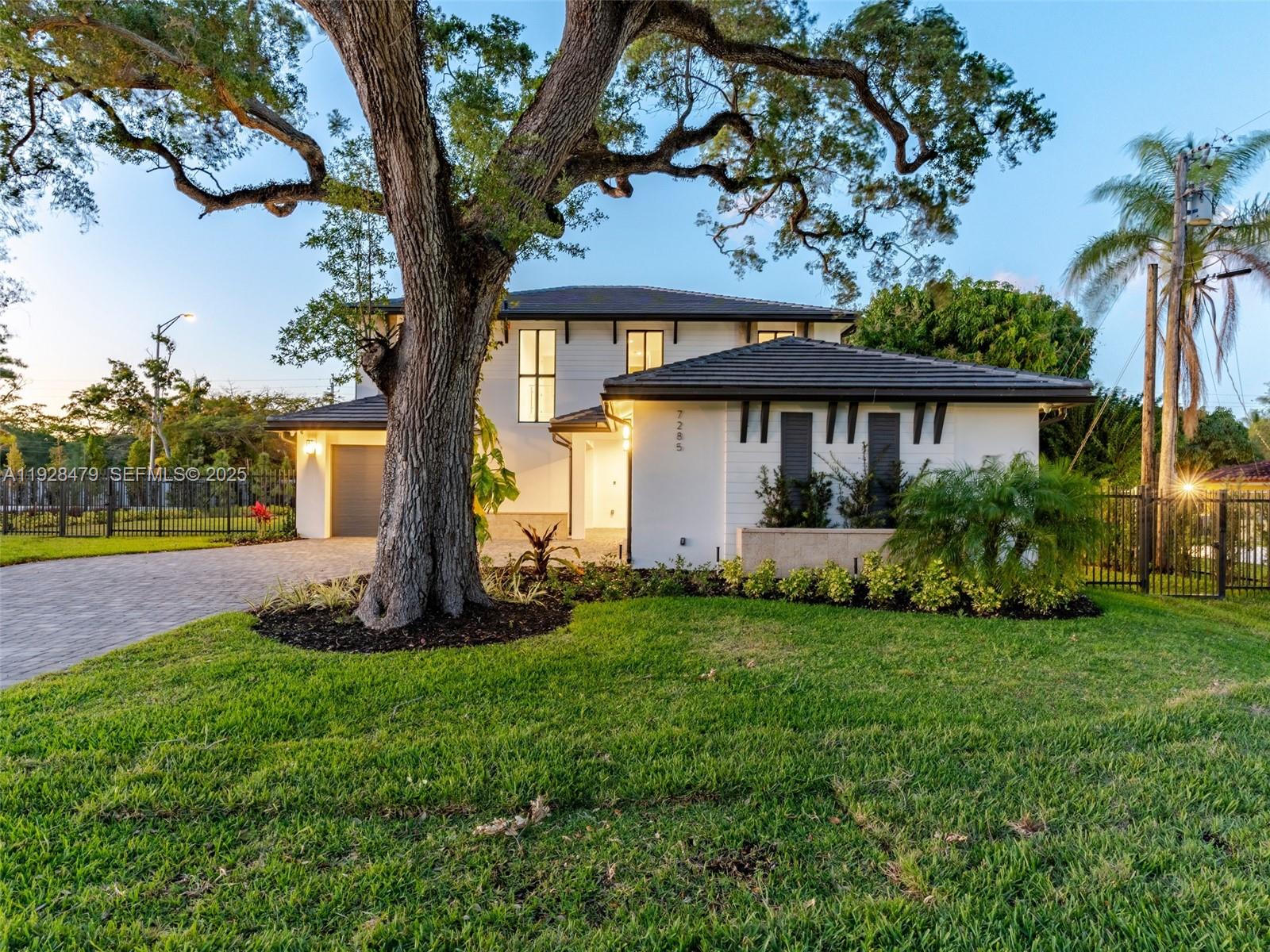 7285 Southwest 72nd Street Miami, FL 33143 - Photo 8 of 53 a front view of a house with a yard and trees
