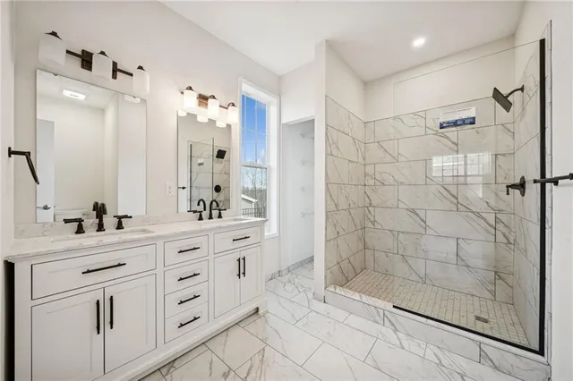 a bathroom with a double vanity sink mirror and shower