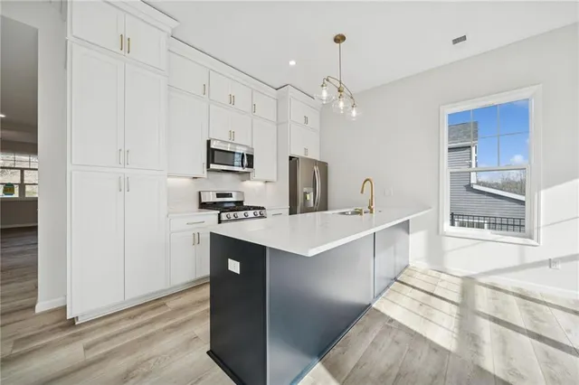 a kitchen with kitchen island a sink stainless steel appliances and counter space