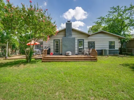 a view of a house with a big yard plants and large trees