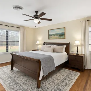 a front view of a house with a garden and trees