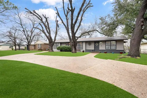 a kitchen with granite countertop a sink cabinets stainless steel appliances and a window
