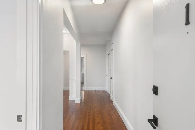 a view of a hallway with wooden floor
