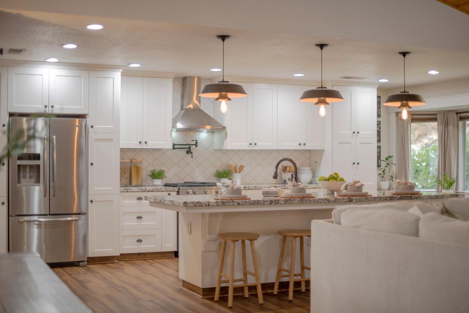 a kitchen with kitchen island granite countertop a sink stove and refrigerator