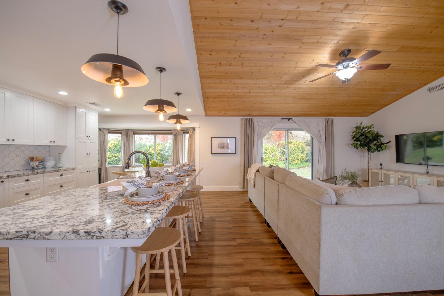 25390 White Thorne Road Clovis, CA 93619 - Photo 16 of 50 a view of living room kitchen with granite countertop furniture and a fireplace