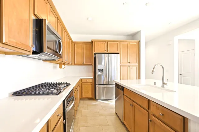 a kitchen with stainless steel appliances a sink stove and cabinets