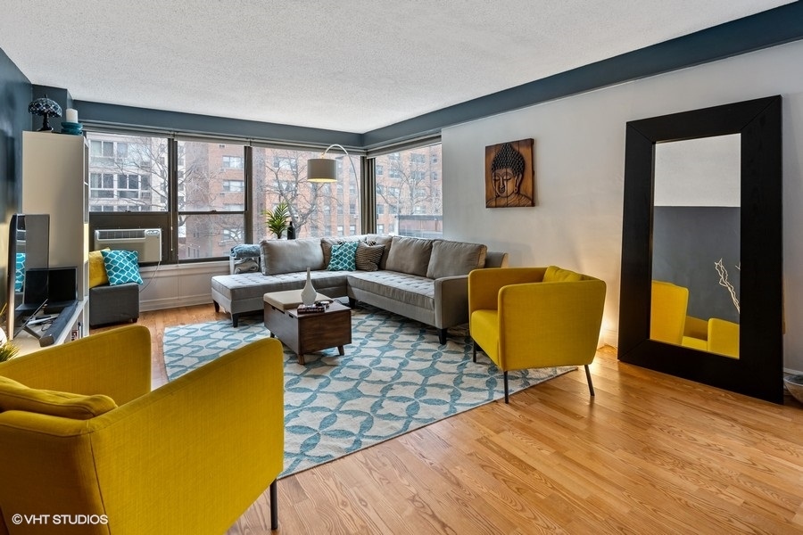 2930 North Sheridan Road, Unit 312 Chicago, IL 60657 - Photo 2 of 14 a living room with furniture and a large window