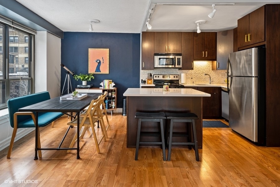 2930 North Sheridan Road, Unit 312 Chicago, IL 60657 - Photo 5 of 14 a view of a dining room with furniture and wooden floor