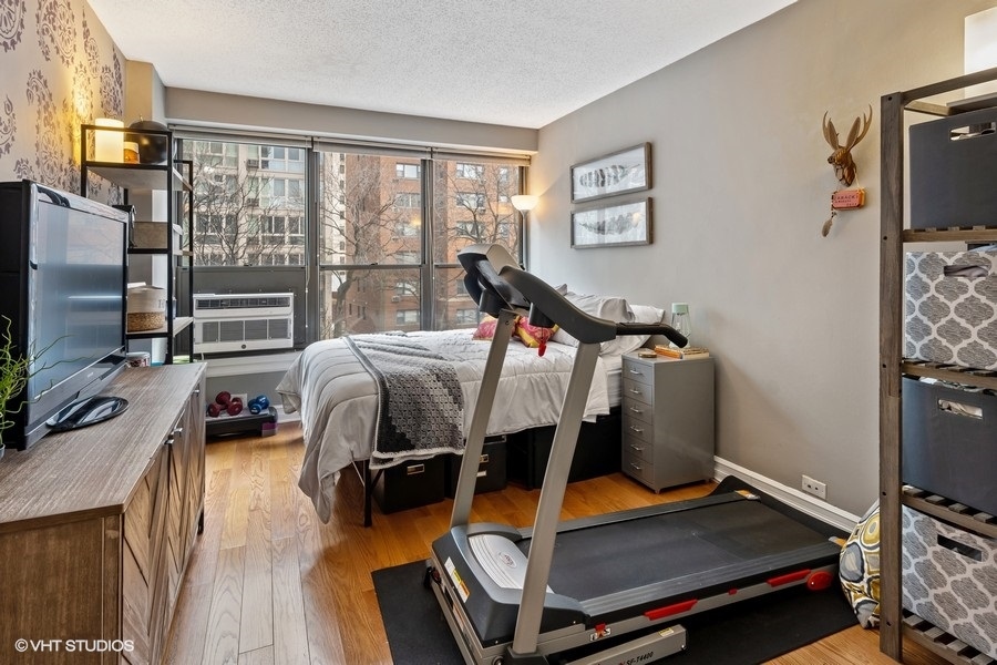 2930 North Sheridan Road, Unit 312 Chicago, IL 60657 - Photo 7 of 14 a bedroom with furniture and a flat screen tv