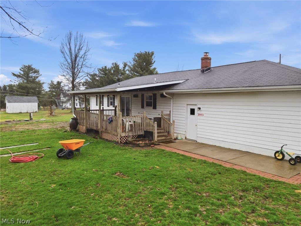 14557 Ellsworth Road Berlin Center, OH 44401 - Photo 5 of 23 Back of house with a lawn, a deck, a chimney, and a shingled roof