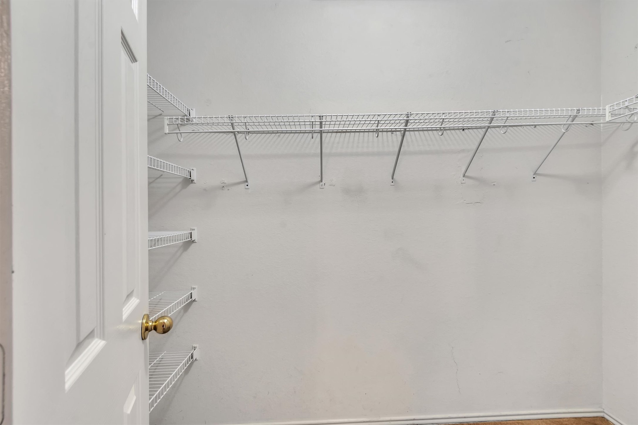 627 Scheel Road Kyle, TX 78640 - Photo 22 of 37 Functional wire shelving and hanging rods create an adaptable storage system within this spacious walk-in closet.