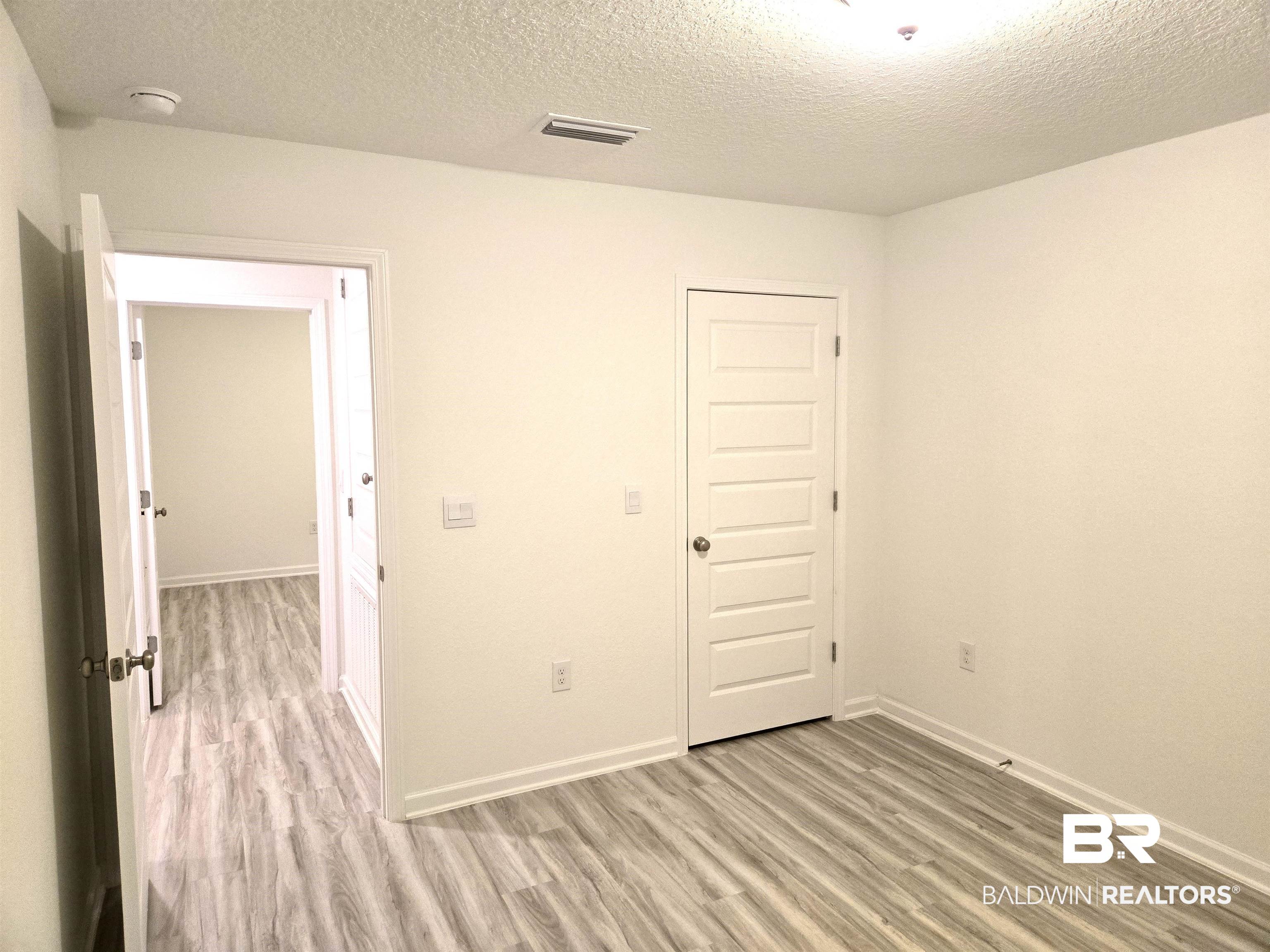 24385 Ringneck Loop Elberta, AL 36530 - Photo 24 of 33 Unfurnished room featuring light wood-type flooring and a textured ceiling
