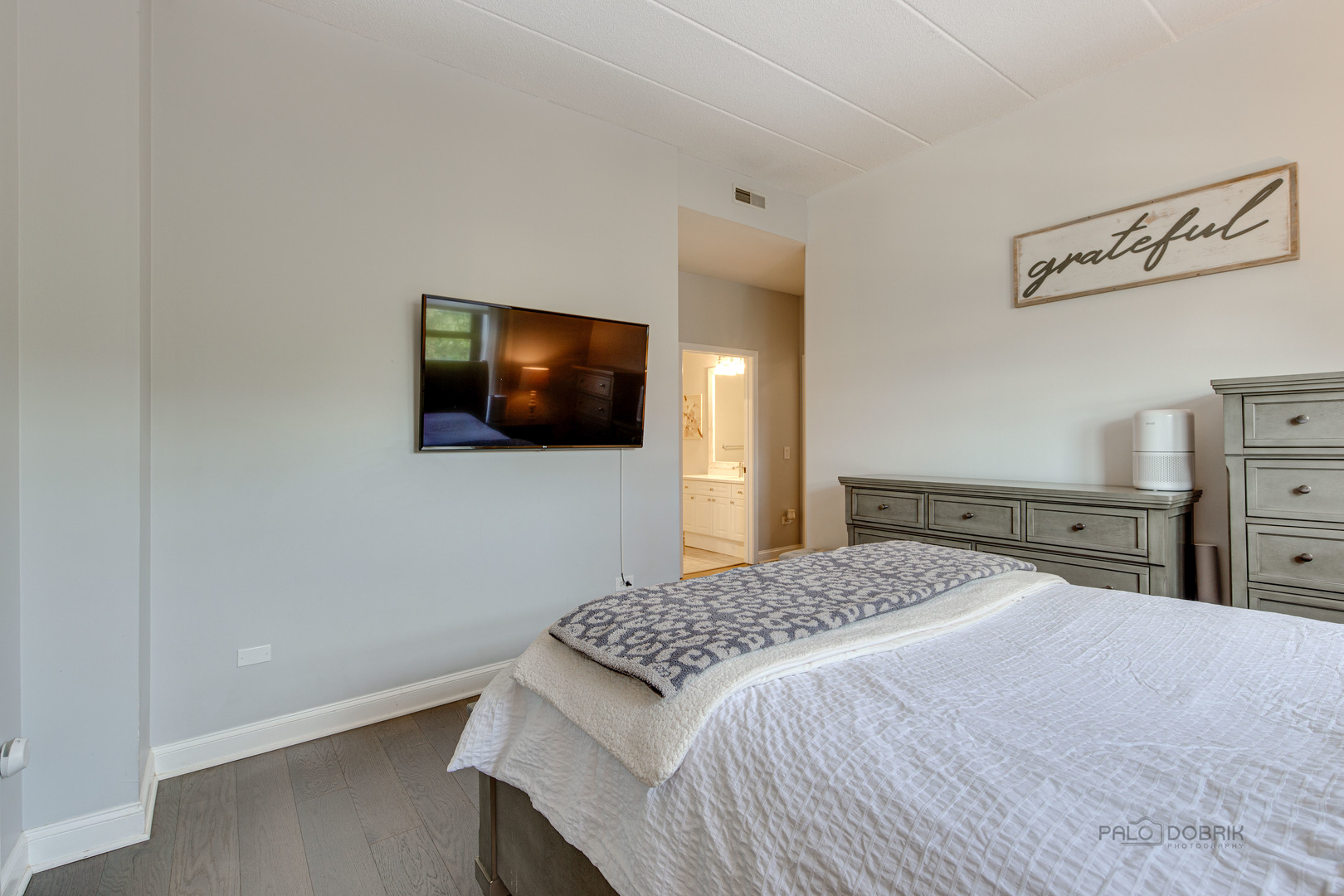 1301 West Washington Boulevard, Unit 309 Chicago, IL 60607 - Photo 17 of 23 a bedroom with a bed and a flat screen tv