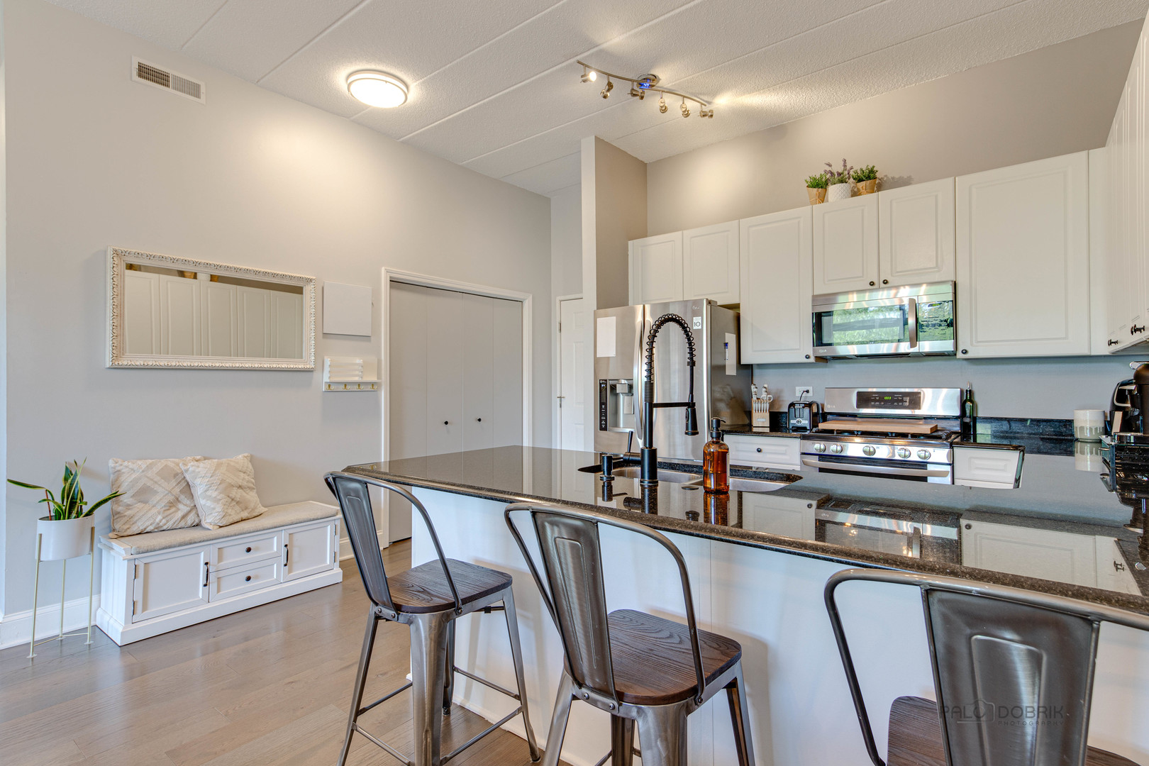 1301 West Washington Boulevard, Unit 309 Chicago, IL 60607 - Photo 8 of 23 a kitchen with stainless steel appliances granite countertop a dining table chairs refrigerator and sink