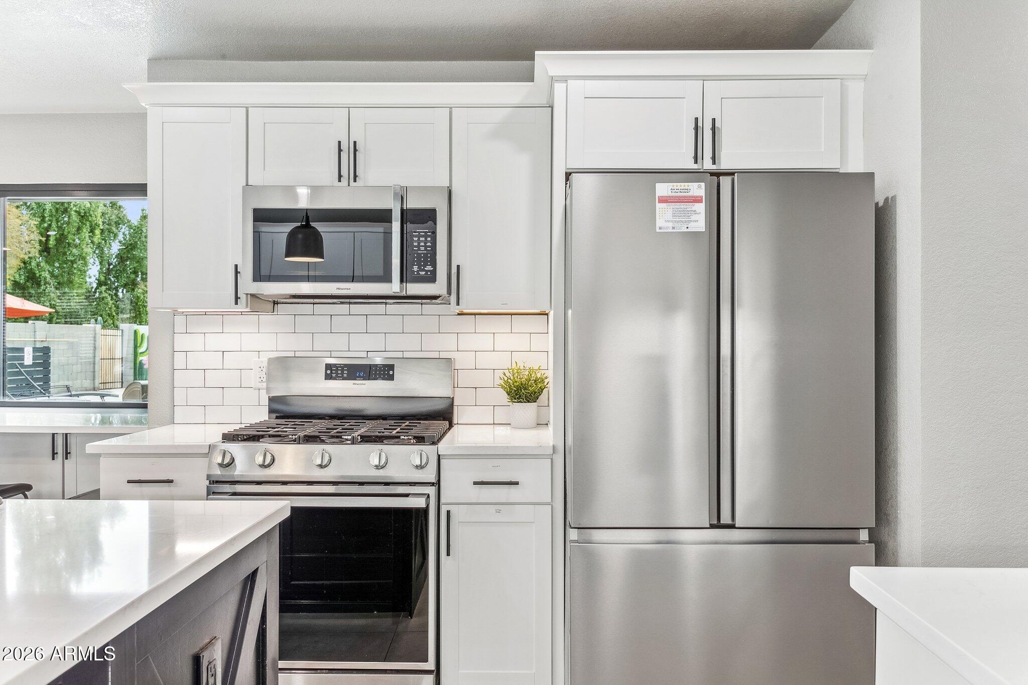 8725 East Osborn Road Scottsdale, AZ 85251 - Photo 9 of 33 a kitchen with stainless steel appliances granite countertop a refrigerator stove and microwave