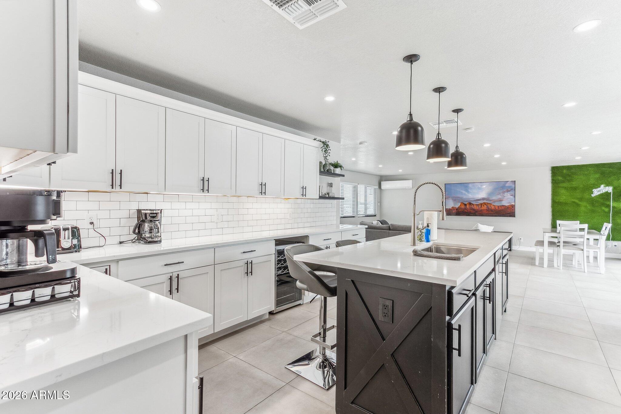 8725 East Osborn Road Scottsdale, AZ 85251 - Photo 10 of 33 a kitchen with stainless steel appliances kitchen island a table chairs sink and cabinets