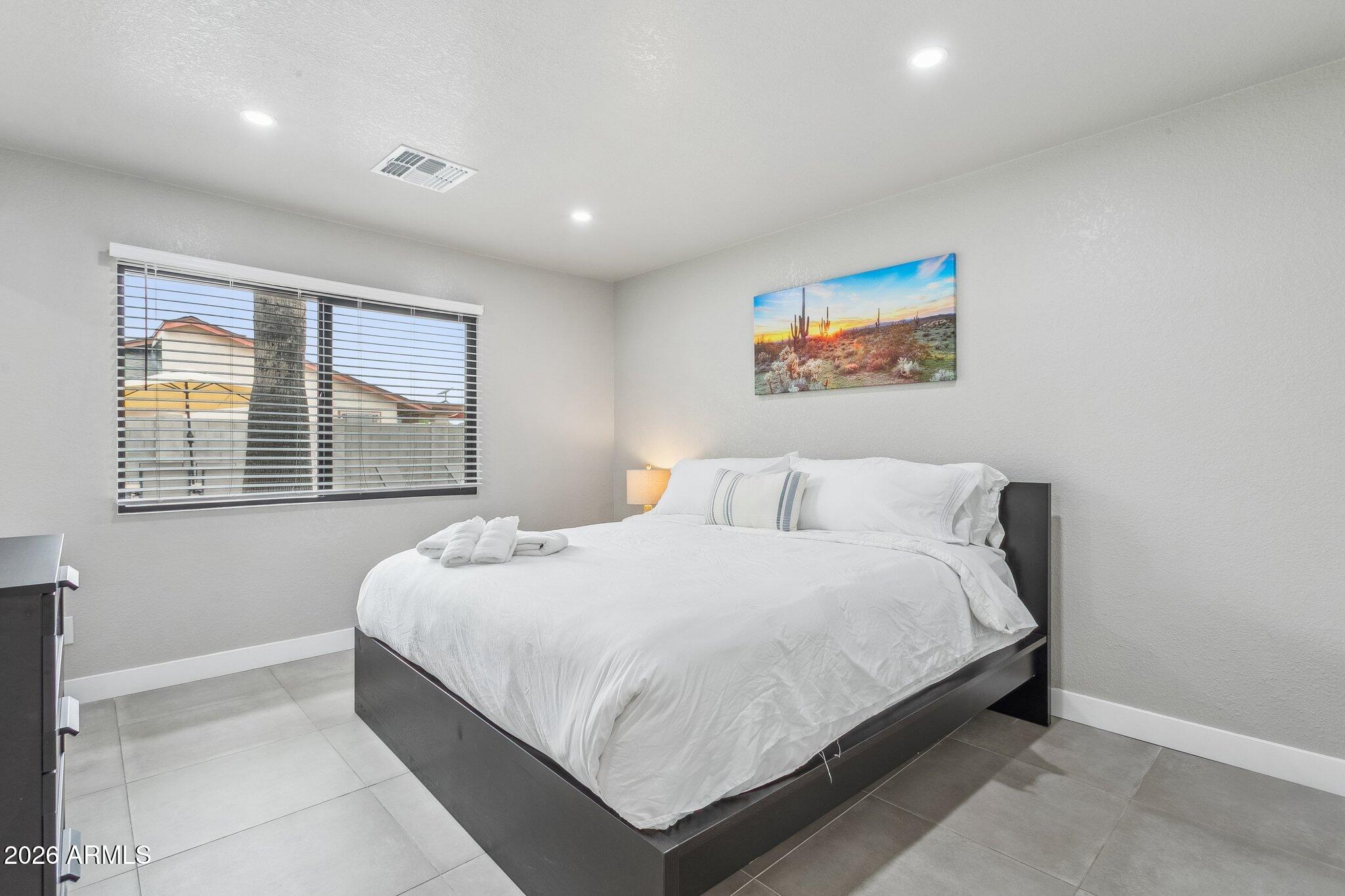 8725 East Osborn Road Scottsdale, AZ 85251 - Photo 15 of 33 a bedroom with a bed and a window