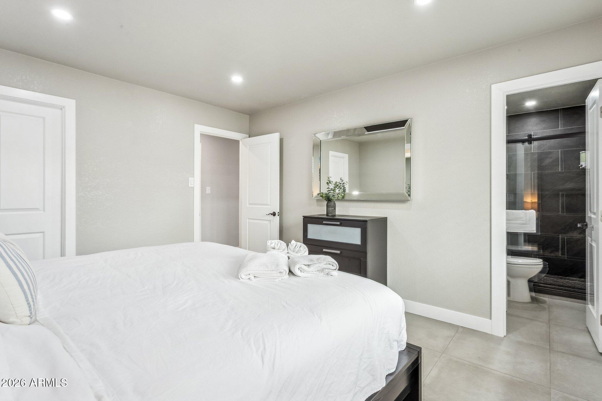 8725 East Osborn Road Scottsdale, AZ 85251 - Photo 16 of 33 a bedroom with a bed and a large mirror