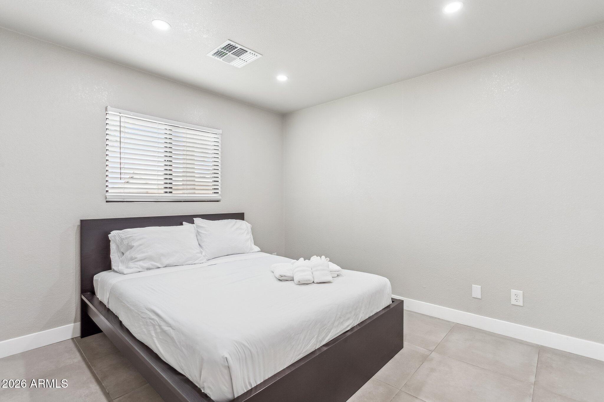 8725 East Osborn Road Scottsdale, AZ 85251 - Photo 19 of 33 a bedroom with a white bed and a window