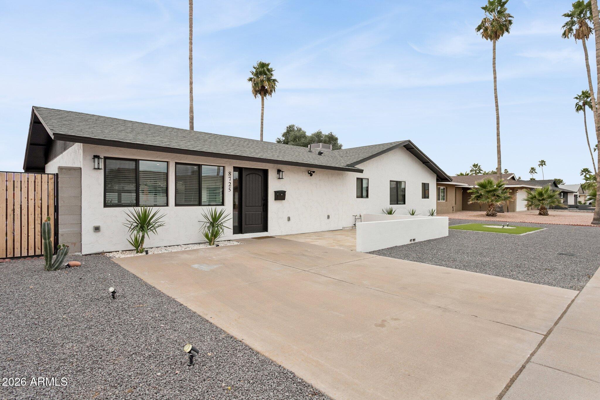 8725 East Osborn Road Scottsdale, AZ 85251 - Photo 6 of 33 a front view of a house with a yard and potted plant