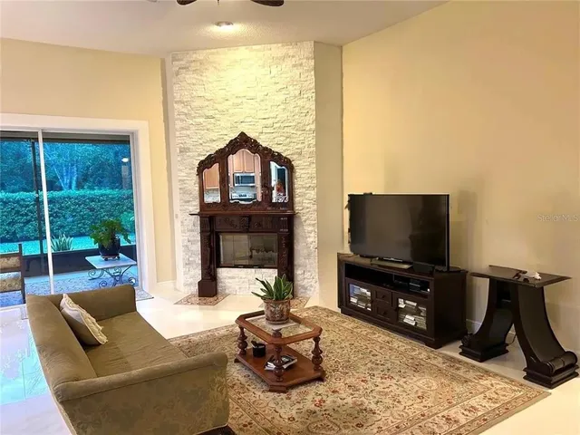 a living room with furniture a flat screen tv and a large window