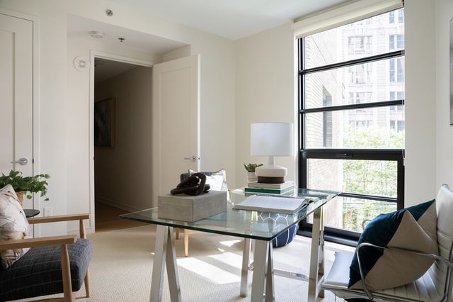 a view of a workspace with furniture and a window